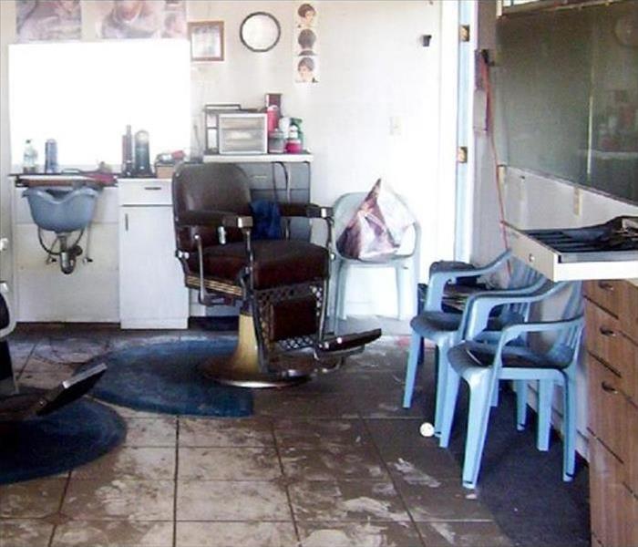 Soot and fire damage visible on floor and walls of salon