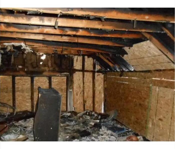 exposed sheathing interior walls of attic, fire debris visible