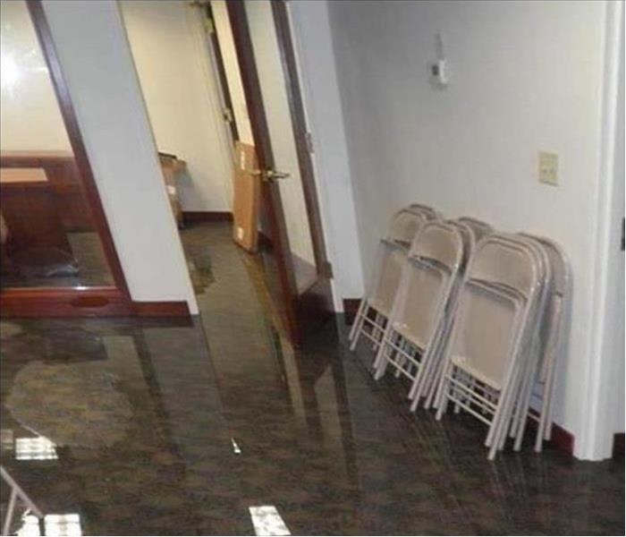 visible water covering floor, chairs leaning on wall