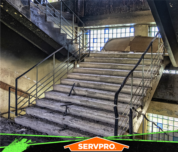 Image of staircase with soot stains on the walls and ceiling from a fire.